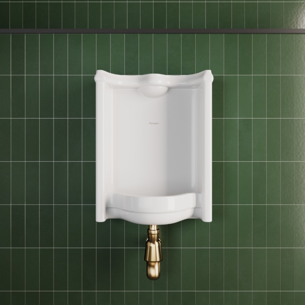 Lifestyle image of the Burlington Whitcomb Urinal with Bracket installed against a green traditional tiled bathroom wall